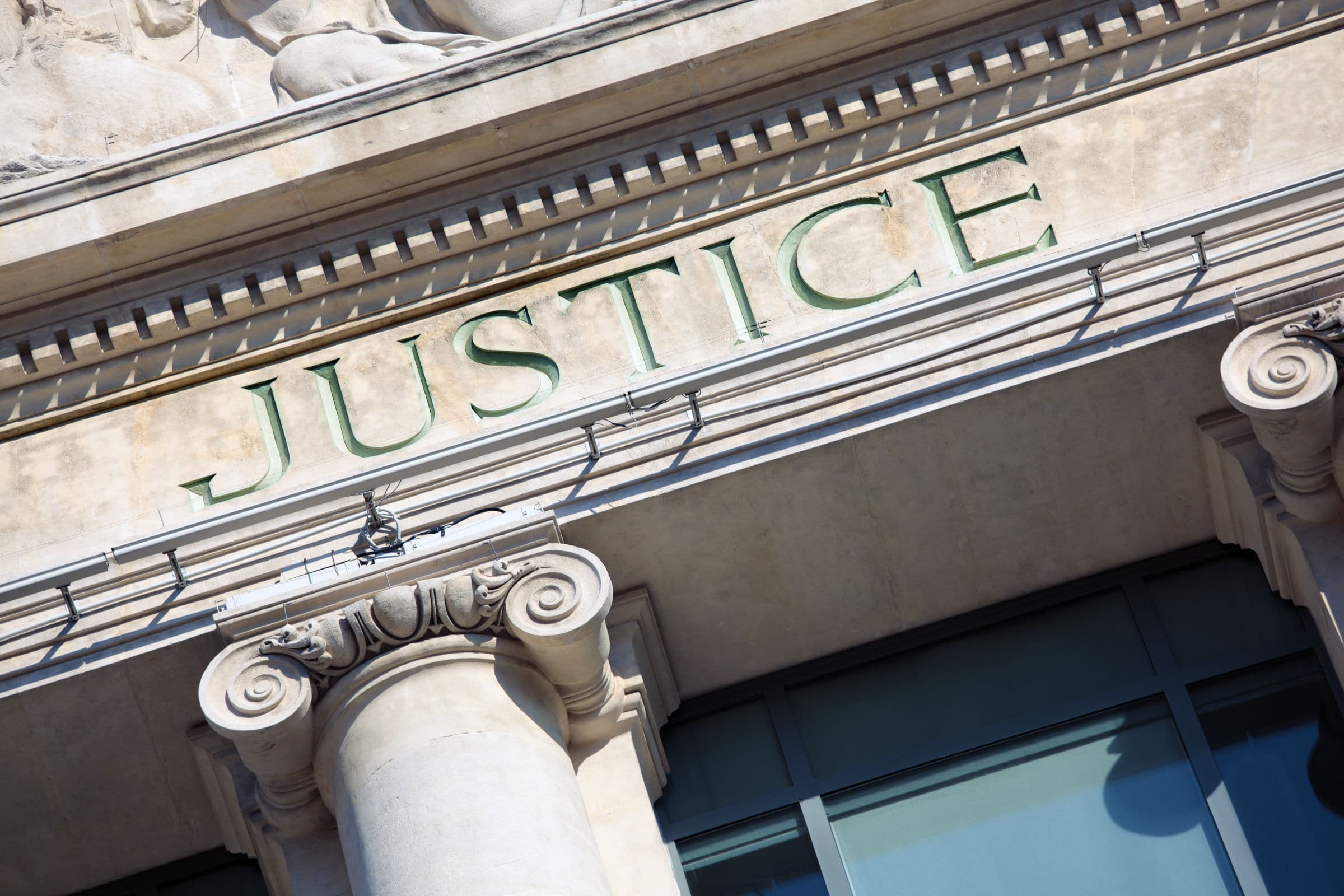 Fachada de tribunal com a palavra Justice